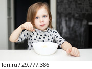 Lovely girl eating soup at home kitchen. Стоковое фото, фотограф ivolodina / Фотобанк Лори