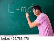 Young male physic standing in front of the green board. Стоковое фото, фотограф Elnur / Фотобанк Лори