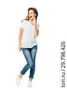 young cheerful girl in jeans, white t-shirt, sneakers and hat holds her palm at open mouth. isolated on white background. Стоковое фото, фотограф Евгения Филимонова / Фотобанк Лори