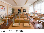 Класс в школе после занятий, стулья сложены на партах (2019 год). Редакционное фото, фотограф Иванов Алексей / Фотобанк Лори