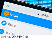 Фрагмент страницы Mail.Ru на экране мобильного телефона на фоне столбиков с числами (2019 год). Редакционное фото, фотограф E. O. / Фотобанк Лори