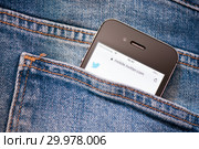 Cайт Twitter на экране сотового телефона. Смартфон лежит в заднем кармане джинсовых штанов (2019 год). Редакционное фото, фотограф E. O. / Фотобанк Лори