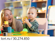 Baby playing with teacher in nursery. Стоковое фото, фотограф Оксана Кузьмина / Фотобанк Лори