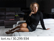 Portrait of young sexy woman in black clothes posing on bed in mattress store. Стоковое фото, фотограф Яков Филимонов / Фотобанк Лори