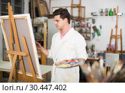 Man near easel painting on canvas. Стоковое фото, фотограф Яков Филимонов / Фотобанк Лори