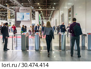 Москва, 2 апреля 2019 года. Выставочный комплекс "Крокус Экспо". Посетители «Мосбилд 2019» проходят через турникет в павильоне № 1. Редакционное фото, фотограф Светлана Васильева / Фотобанк Лори