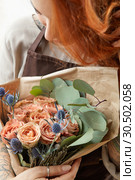 Young girl with red hair holds beautiful bunch of roses living coral colored. Close-up. Conept of celebrating of Mother's Day. Стоковое фото, фотограф Ярослав Данильченко / Фотобанк Лори