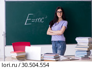 Young female teacher student in front of green board. Стоковое фото, фотограф Elnur / Фотобанк Лори