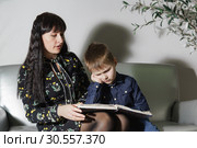 Мама с маленьким сыном учат уроки. Мальчик устал, не хочет читать и злится. Поздний вечер. Стоковое фото, фотограф Наталья Гармашева / Фотобанк Лори