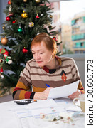 Mature woman calculates utility costs in the new year. Стоковое фото, фотограф Яков Филимонов / Фотобанк Лори