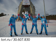 Волонтёры Всемирной зимней универсиады 2019 стоят, взявшись за руки, на склоне горы. Редакционное фото, фотограф Светлана Грызлова / Фотобанк Лори