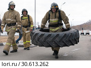 Сотрудник МЧС России переносит покрышку от грузовика. Функциональное пожарно-спасательное многоборье (2019 год). Редакционное фото, фотограф А. А. Пирагис / Фотобанк Лори