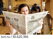 The girl reads the newspaper in Baranochka Candies cafe. a look in a fullface (2019 год). Редакционное фото, фотограф Владимир Арсентьев / Фотобанк Лори