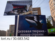 Женщина держит плакат с надписью "Китовая тюрьма - позор страны" на первомайском марше в защиту животных по центральным улицам города Москвы, Россия (2019 год). Редакционное фото, фотограф Николай Винокуров / Фотобанк Лори