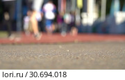 Blurred background of runners on stadium. Amateur sport footage slowmotion. Стоковое видео, видеограф Dmitry Domashenko / Фотобанк Лори