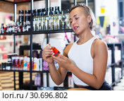woman buyer choosing bottle of pheromones. Стоковое фото, фотограф Яков Филимонов / Фотобанк Лори