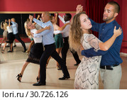 Positive adult couples dancing tango together in modern studio. Стоковое фото, фотограф Яков Филимонов / Фотобанк Лори