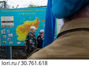 Ветеран Афганской войны держит флаг ВДВ на фоне карты Афганистана в сквере Воинов-интернационалистов на улице Ленина в центре города Севастополя (2019 год). Редакционное фото, фотограф Николай Винокуров / Фотобанк Лори
