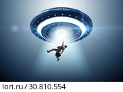 Flying saucer abducting young businessman. Стоковое фото, фотограф Elnur / Фотобанк Лори