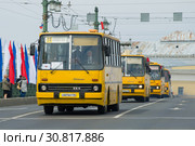 Колонна желтых венгерских автобусов "Икарус" на Дворцовом мосту. Фрагмент парада ретротранспорта в День города. Санкт-Петербург (2019 год). Редакционное фото, фотограф Виктор Карасев / Фотобанк Лори