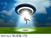 Flying saucer abducting young businessman. Стоковое фото, фотограф Elnur / Фотобанк Лори
