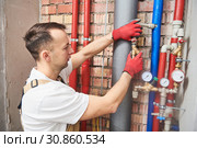 plumber installing and mounting water equipment - meter, filter and pressure reducer. Стоковое фото, фотограф Дмитрий Калиновский / Фотобанк Лори
