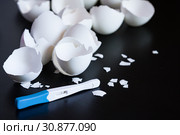 Infertility. Negative pregnancy test and eggshell on black. Стоковое фото, фотограф Papoyan Irina / Фотобанк Лори