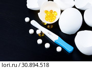 Infertility. Negative pregnancy test and eggshell on black. Стоковое фото, фотограф Papoyan Irina / Фотобанк Лори