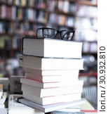 glasses on top of stack of books lying on table in bookstore. Стоковое фото, фотограф Татьяна Яцевич / Фотобанк Лори
