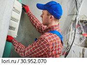 Electrician works with pliers in switchbox. current breaker installation. Стоковое фото, фотограф Дмитрий Калиновский / Фотобанк Лори