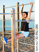 Man doing workout on beach holding L-sit on wall bars. Стоковое фото, фотограф Яков Филимонов / Фотобанк Лори