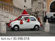Санта-Клаус (Santa Claus) с мешком подарков в легковой машине. Рим, Италия (2014 год). Редакционное фото, фотограф Светлана Колобова / Фотобанк Лори