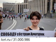 Девушка держит плакат с требованием оправдательного приговора для сестер Хачатурян на митинге против политических репрессий и фабрикации уголовных дел на проспекте Сахарова в городе Москве, Россия (2019 год). Редакционное фото, фотограф Николай Винокуров / Фотобанк Лори