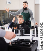 outraged man client expressing dissatisfaction about his haircut at hair salon. Стоковое фото, фотограф Яков Филимонов / Фотобанк Лори