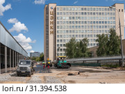 Москва, улица Пруд-Ключики, д 12А. Здание ЦЭНКИ - Центра эксплуатации объектов наземной космической инфраструктуры. Перед зданием укладывают асфальт (2019 год). Редакционное фото, фотограф Наталья Николаева / Фотобанк Лори