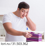 Young man with gift bag at home preparing suprise for wife. Стоковое фото, фотограф Elnur / Фотобанк Лори