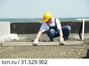 Roof construction. worker roofer leveling with float lute. Стоковое фото, фотограф Дмитрий Калиновский / Фотобанк Лори