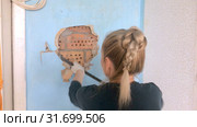 The young woman does repair in the apartment. The worker a hand tool breaks off an old wall covering under which the brick wall is visible. Стоковое видео, видеограф Куликов Константин / Фотобанк Лори