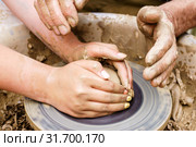 Two pairs of hands mold something from clay on a potter's wheel. Стоковое фото, фотограф Евгений Харитонов / Фотобанк Лори