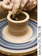 Potter's hands mold pottery on a rotating wheel. Стоковое фото, фотограф Евгений Харитонов / Фотобанк Лори