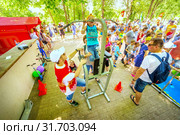 Russia Samara June 2019: a girl passes the standards for pulling up on a horizontal bar in the park sunny day. Text in Russian: Judge Gto. Редакционное фото, фотограф Акиньшин Владимир / Фотобанк Лори