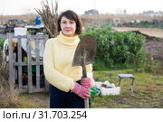 Girl in a yellow sweater digs beds with a shovel. Стоковое фото, фотограф Яков Филимонов / Фотобанк Лори