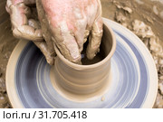 Potter's hands mold pottery on a rotating wheel. Стоковое фото, фотограф Евгений Харитонов / Фотобанк Лори