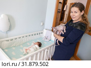 Mother remove cat from children crib for keep sleeping newborn baby, sphynx prevents infant sleep. Стоковое фото, фотограф Кекяляйнен Андрей / Фотобанк Лори