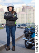 Young woman motorcyclist standing roadside near her motorcycle, full length portrait with cross arms on breast. Стоковое фото, фотограф Кекяляйнен Андрей / Фотобанк Лори
