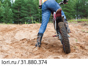 Adult man riding on sandy dirt track with his motorcross motorcycle, rear view, copyspace. Стоковое фото, фотограф Кекяляйнен Андрей / Фотобанк Лори