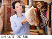 Adult woman shopping carpet and showing samples. Стоковое фото, фотограф Яков Филимонов / Фотобанк Лори
