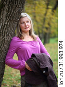 Young woman in autumn park stands near a tree. Стоковое фото, фотограф Марина Володько / Фотобанк Лори