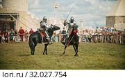 BULGAR, RUSSIA 11-08-2019: Knights with swords riding horses on the battlefield and having a training battle - people watching behind the fence. Редакционное видео, видеограф Константин Шишкин / Фотобанк Лори