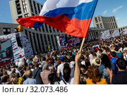 Российский триколор развевается над толпой во время митинга-концерта в честь Дня российского флага на проспекте Сахарова.в городе Москве, Россия (2019 год). Редакционное фото, фотограф Николай Винокуров / Фотобанк Лори